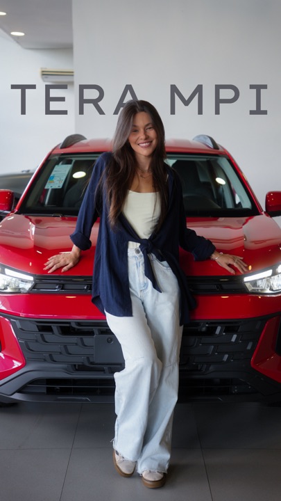 Carol em frente ao VW Tera vermelho, gravando para a Volkswagen